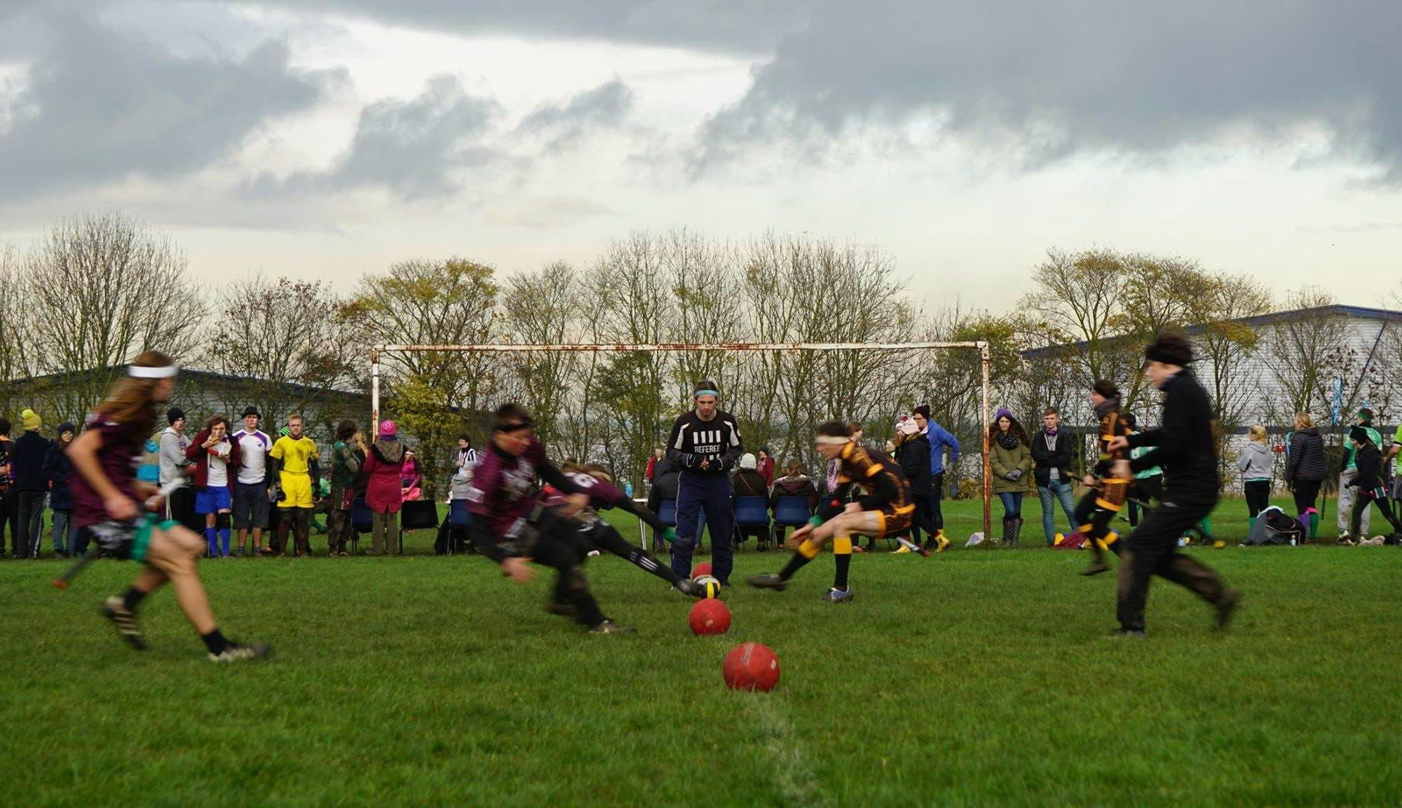 Two teams run towards the halfway line to begin a game of Quidditch